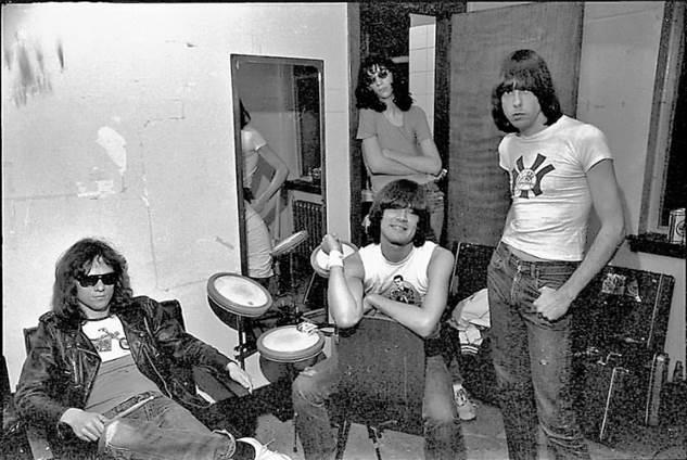The four members of The Ramones stood in their dressing room wearing sunglasses and white vest tops