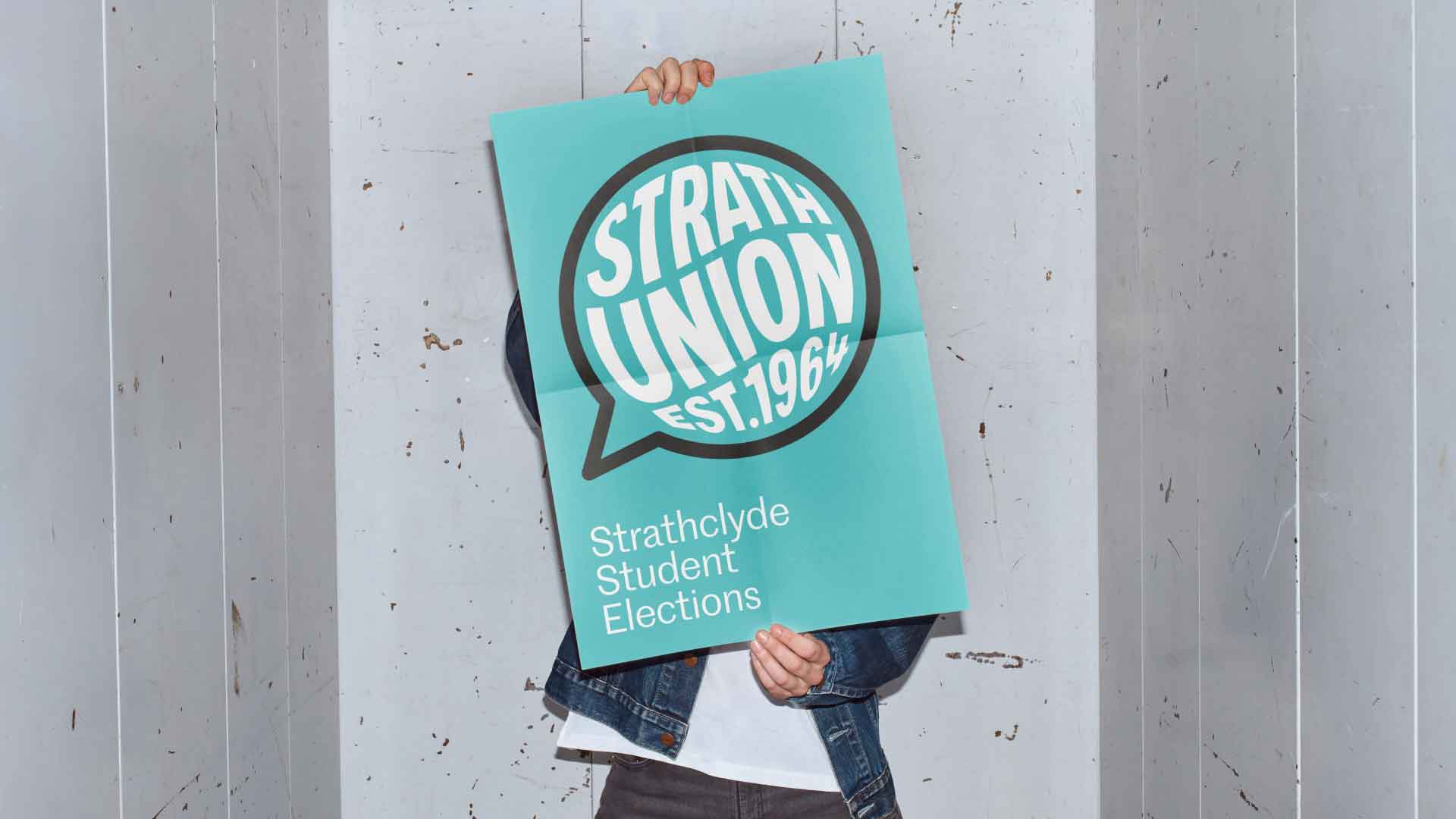 Person holding Strathclyde Student Elections poster in front of their face.