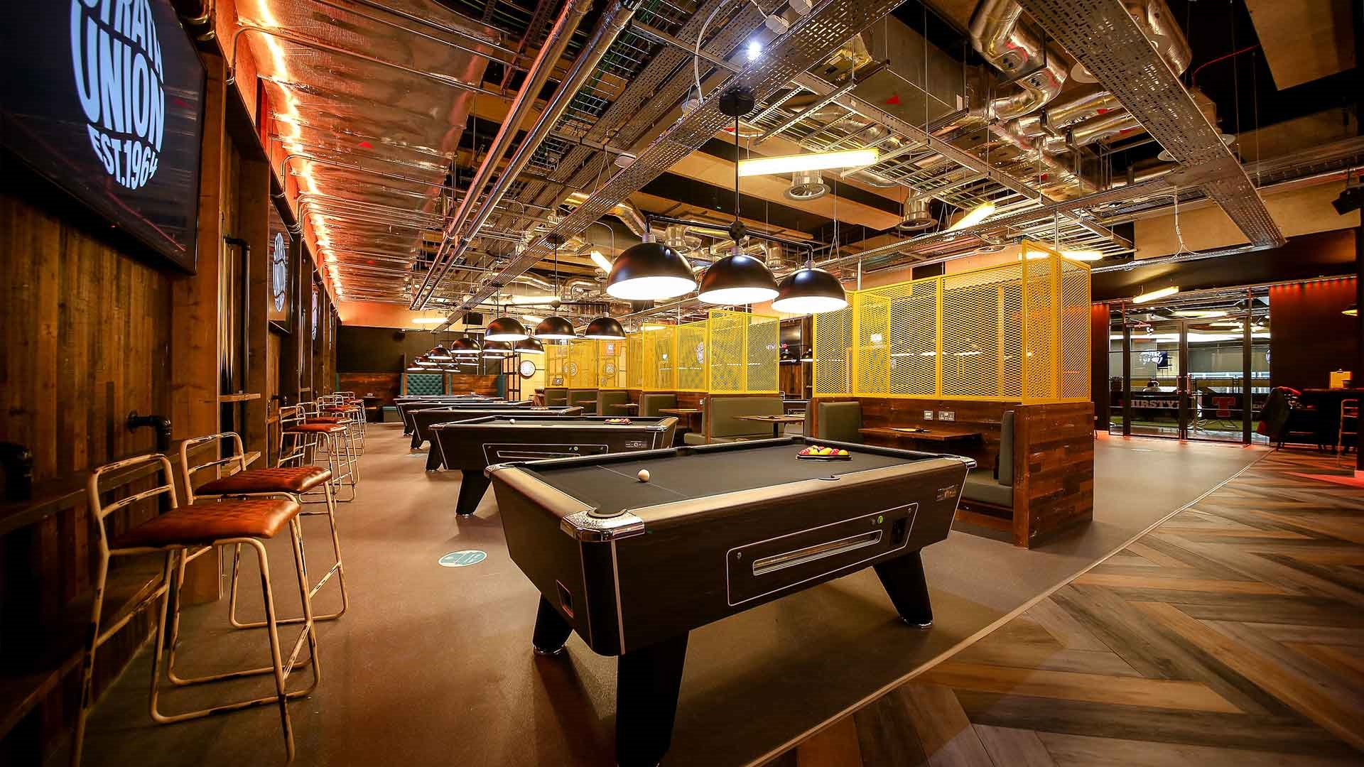 Pool tables and bar stools arranged in one of the Strath Union venues