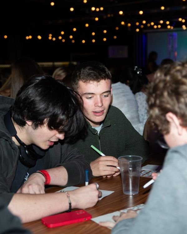 Students marking bingo card with pens.