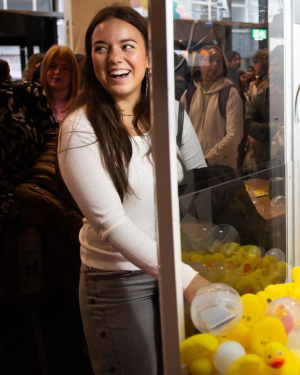 Student winning prize at claw machine.