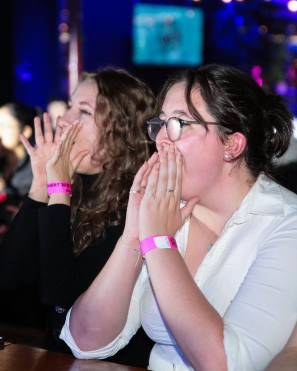 Two students cheering at drag show.