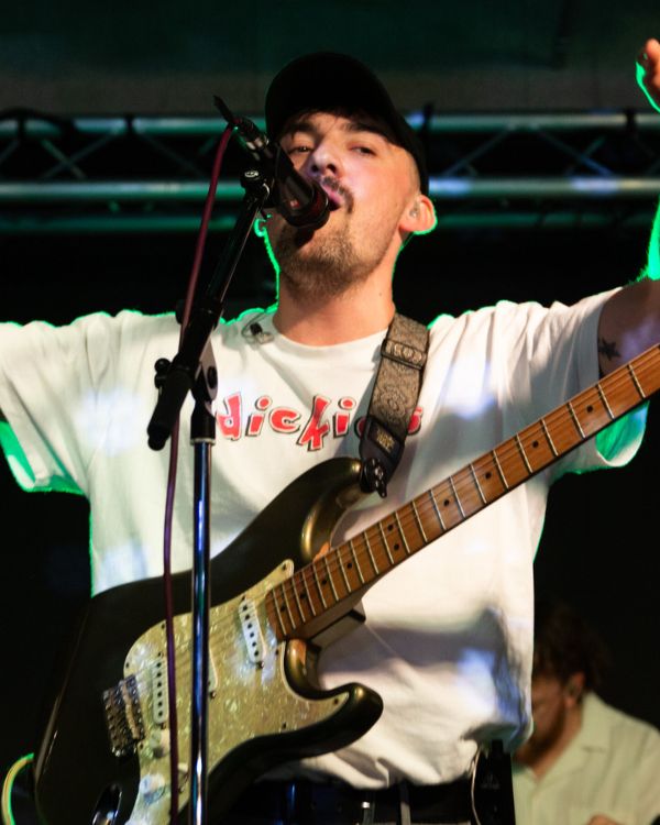 Performer on stage playing guitar.