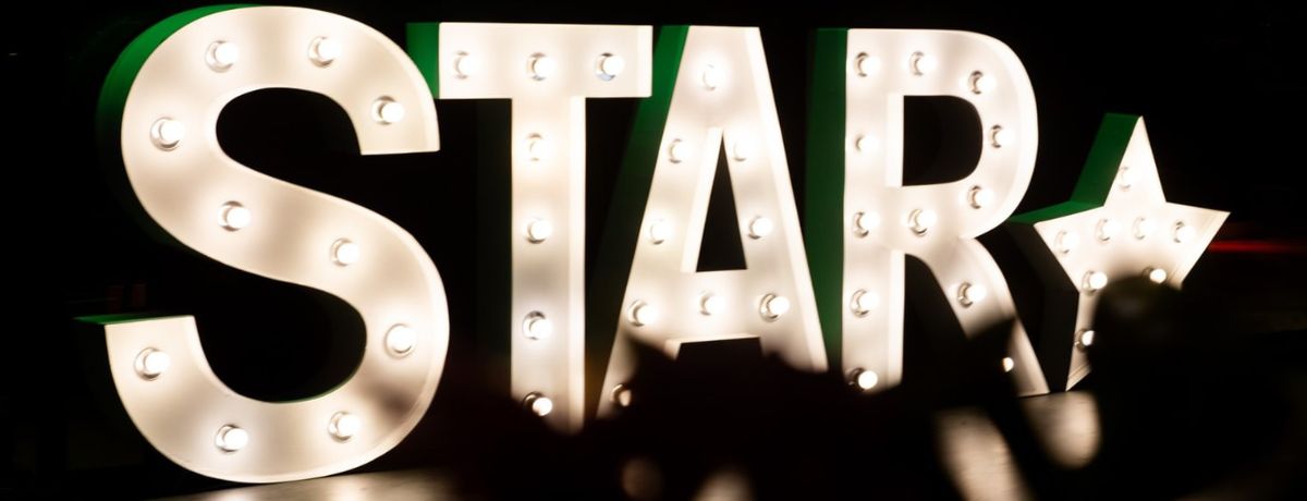 Light box letters spelling out STAR, with a star shape after the final letter.