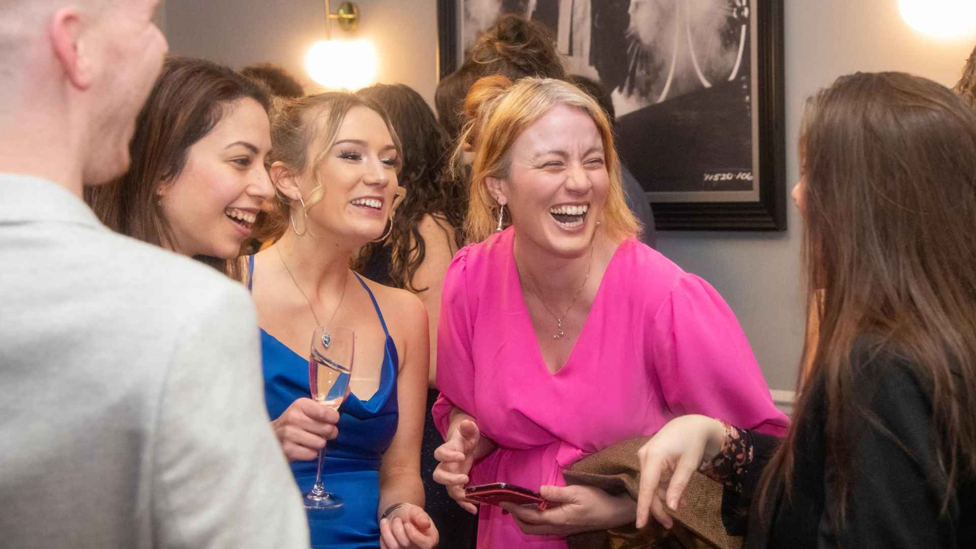 Group of people laughing and talking at grad ball