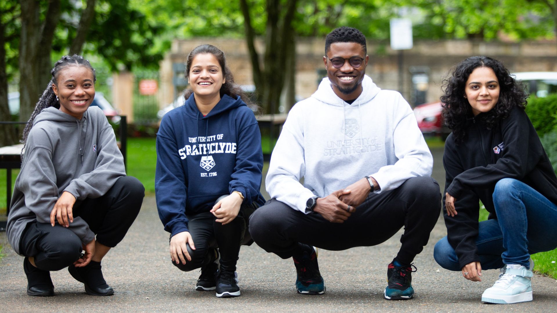 Group of 4 students wearing University of Strathclyde shop hoodies.
