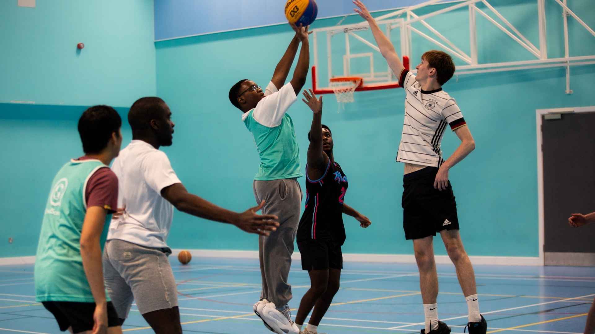 Student playing basketball in Sports Hall