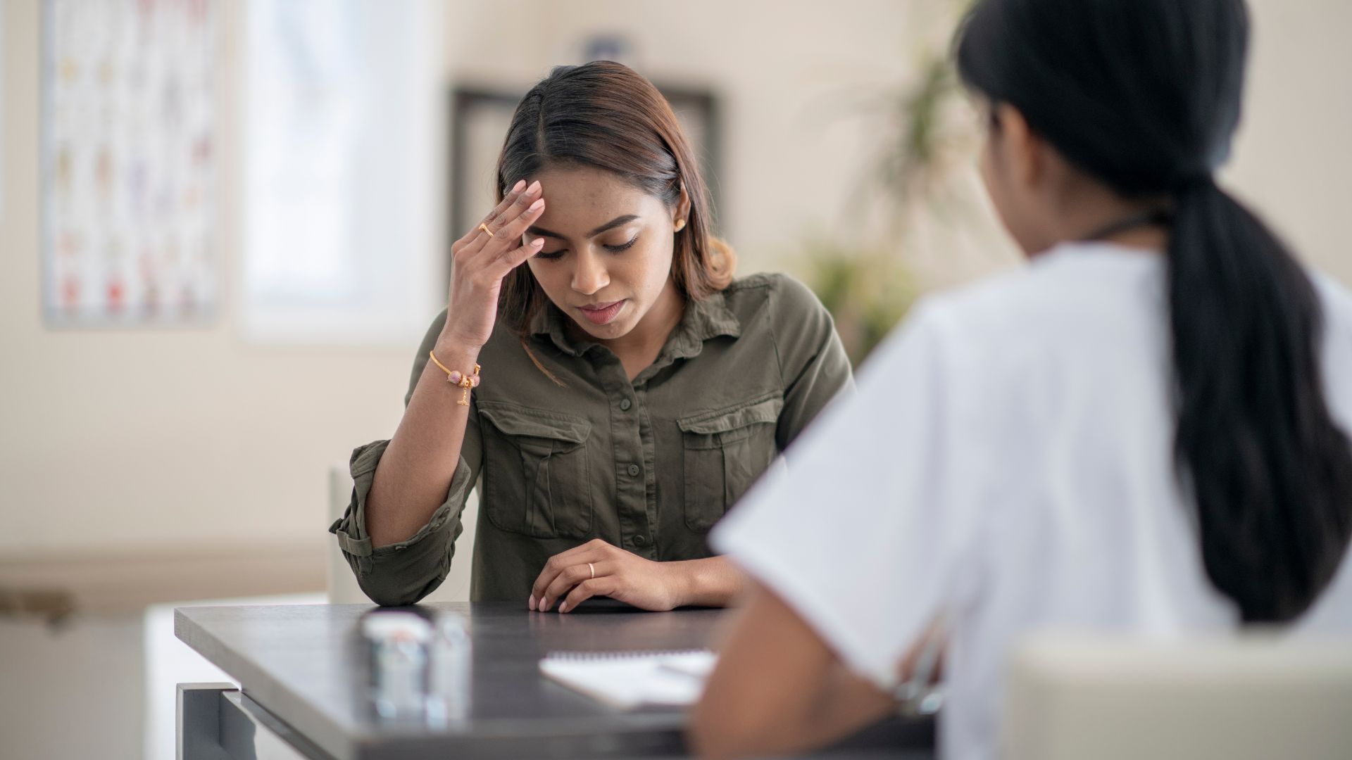 Person chatting to another holding their head