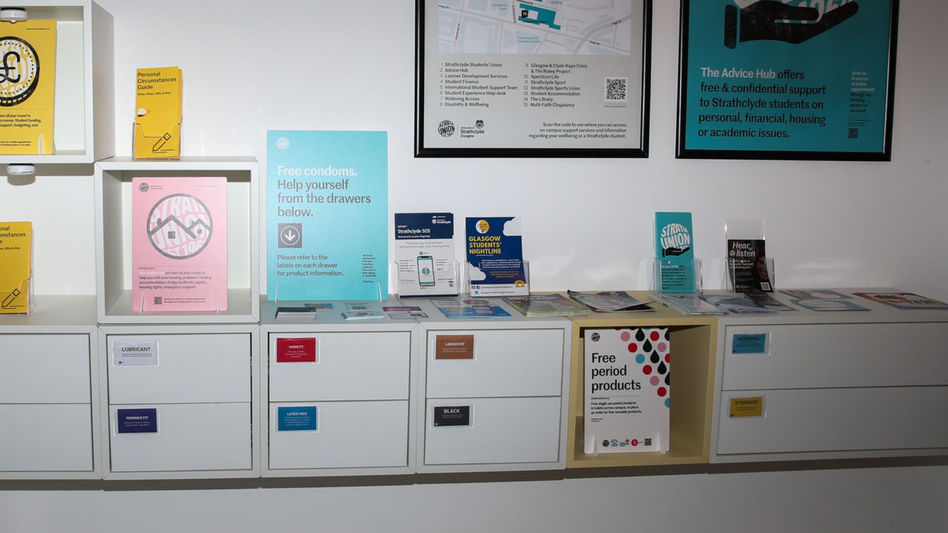Wide shot of wall mounted storage unit holding free condoms and period products.
