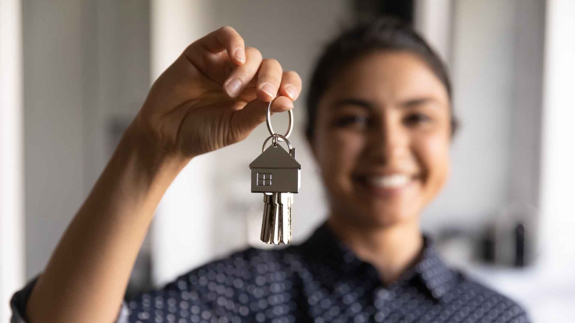 Person holding up house keys and smiling
