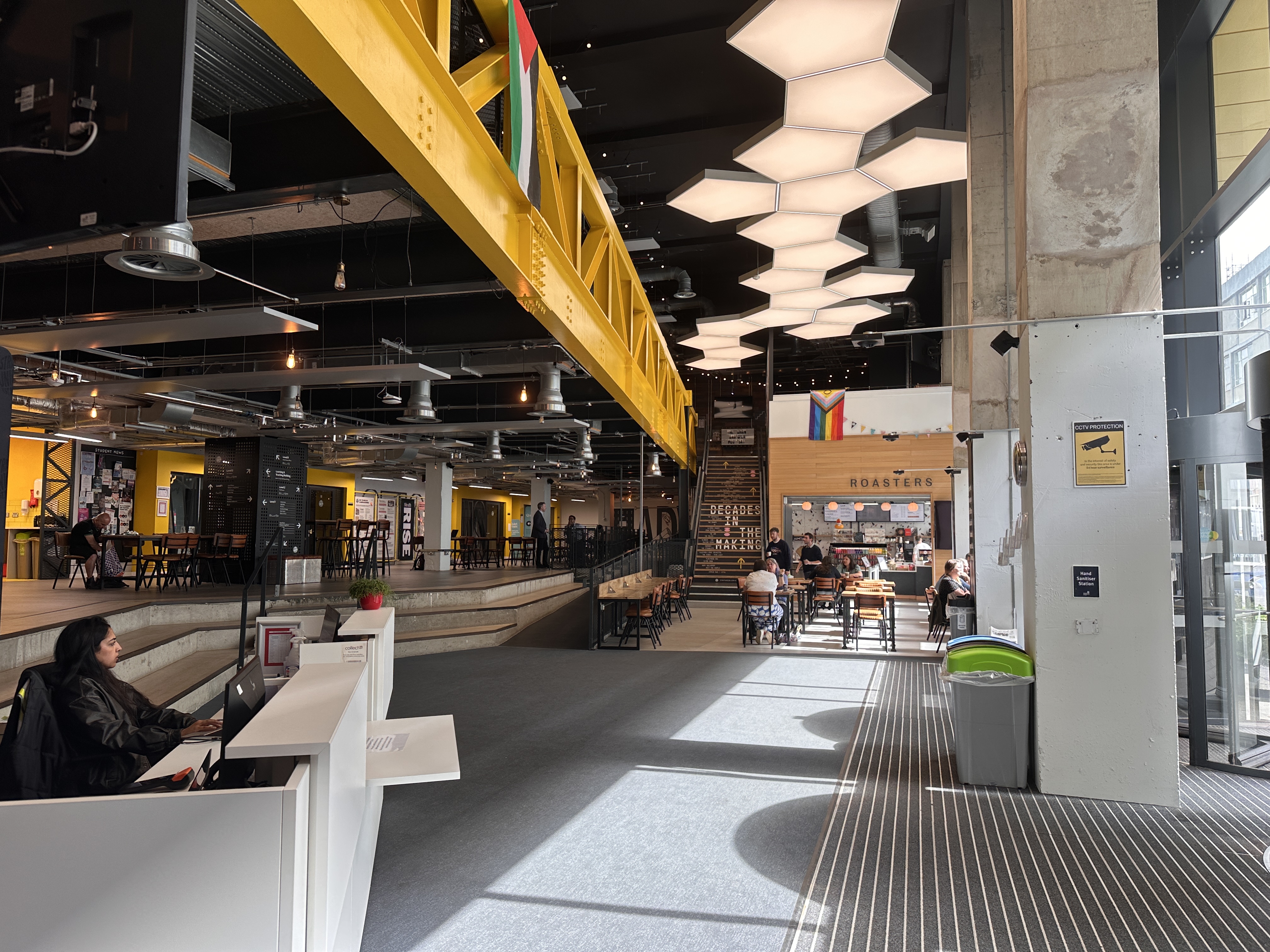 Wide shot of the inside of the Union entrance featuring Roasters, Welcome Desk and ramp.