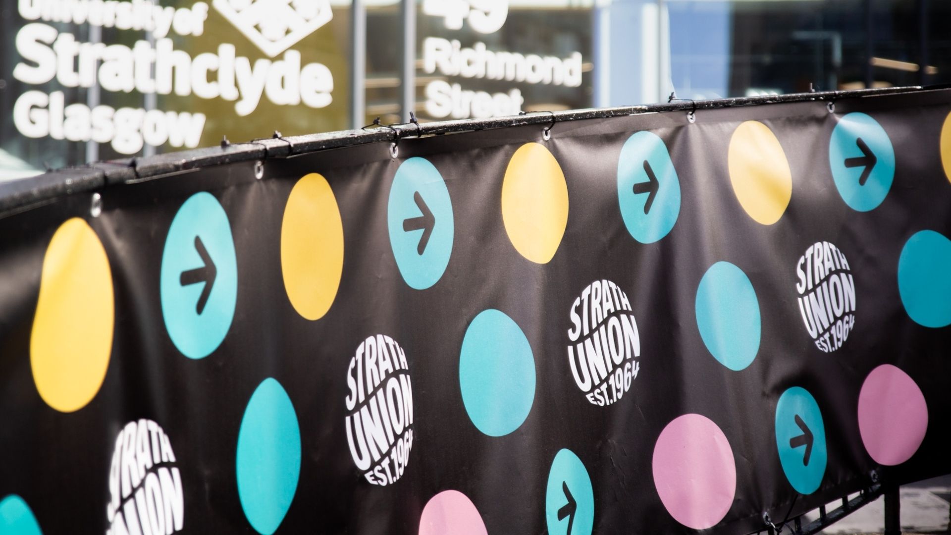 Banner with Strath Union logo alongside yellow, green and pink dots