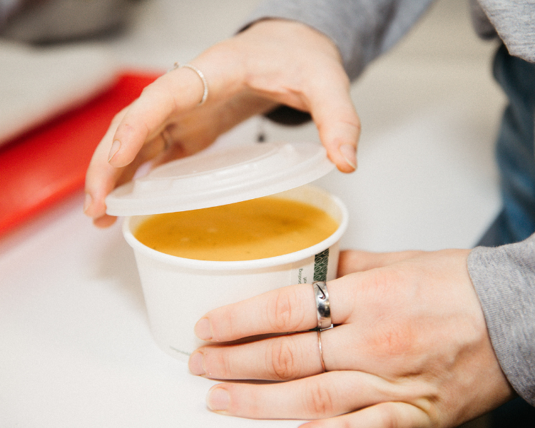 A barista wearing a mask while making a coffee