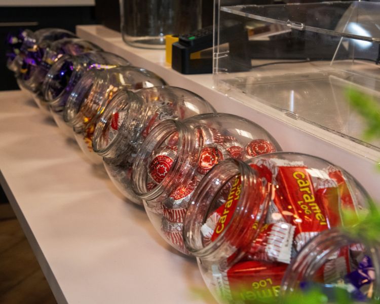 Chocolate bars displayed in sweet jars on counter.