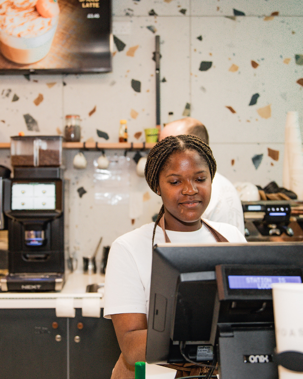 Member of Roasters staff serving at the till
