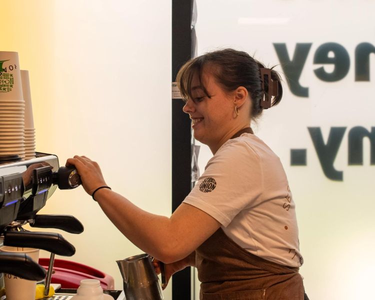 A barista making coffee at Roasters.