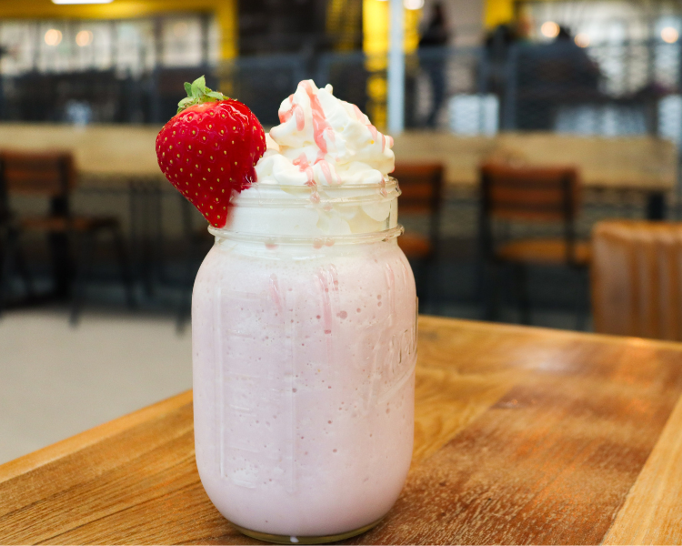 A strawberry milkshake on a table at Roasters