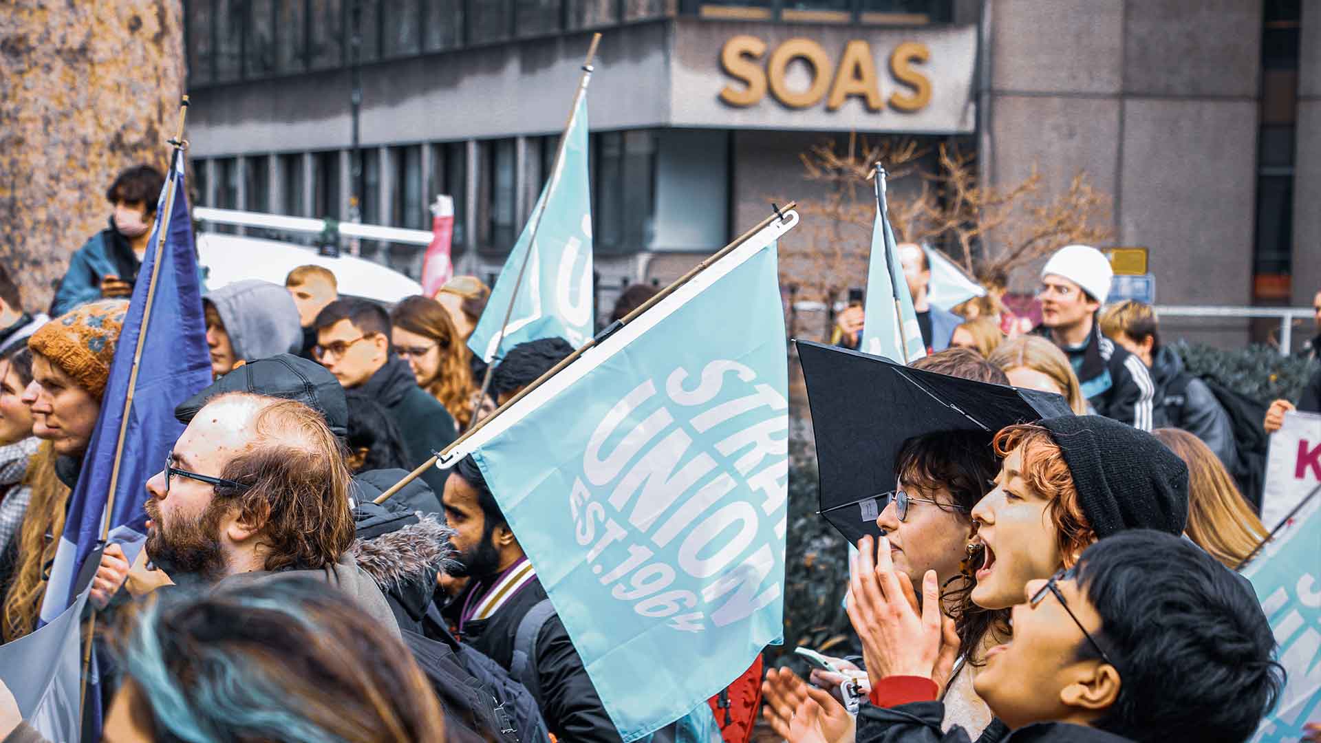 Strath students at a campaign march waving blue Strath Union flags