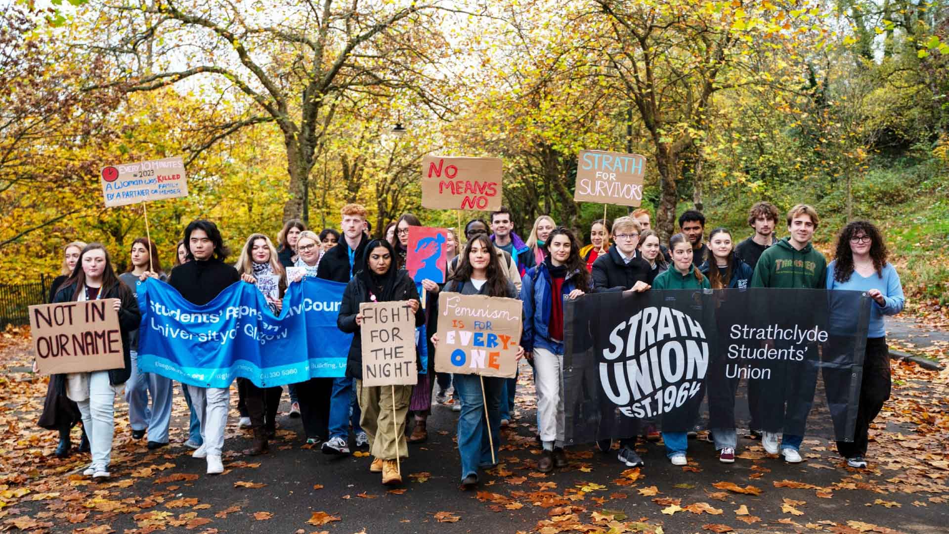 Students from Strath Union and Glasgow Uni's SRC, holding banners with messages against gender-based violence.