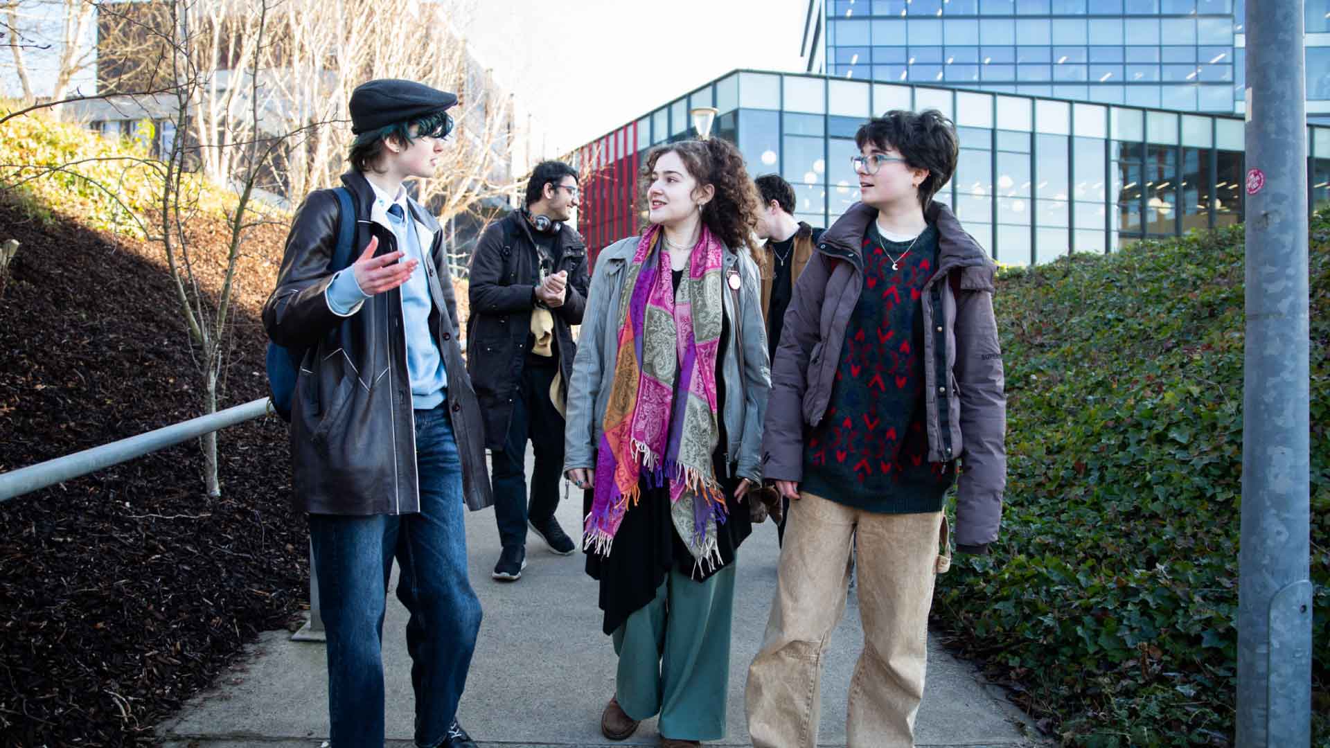 Group of students walking and talking on Strathclyde campus.