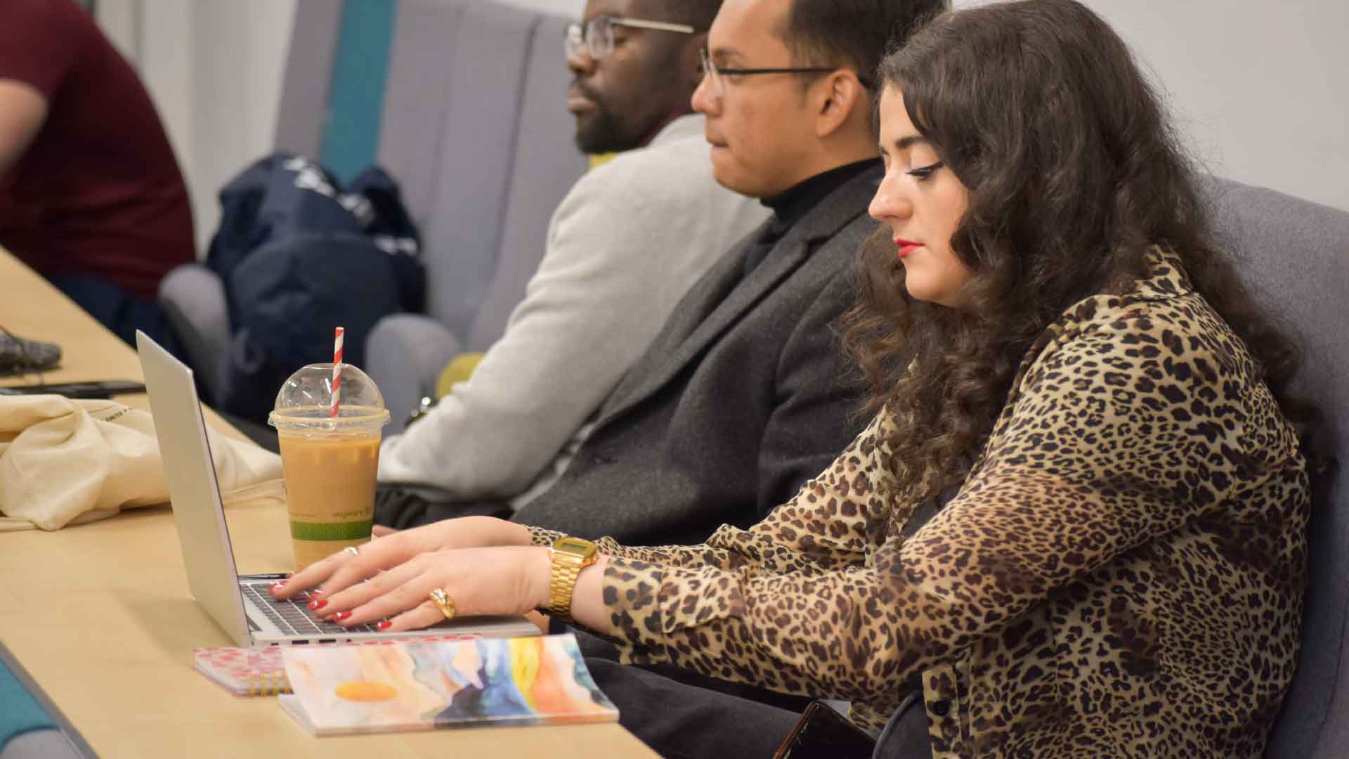 Person in Mandela Auditorium, typing on laptop