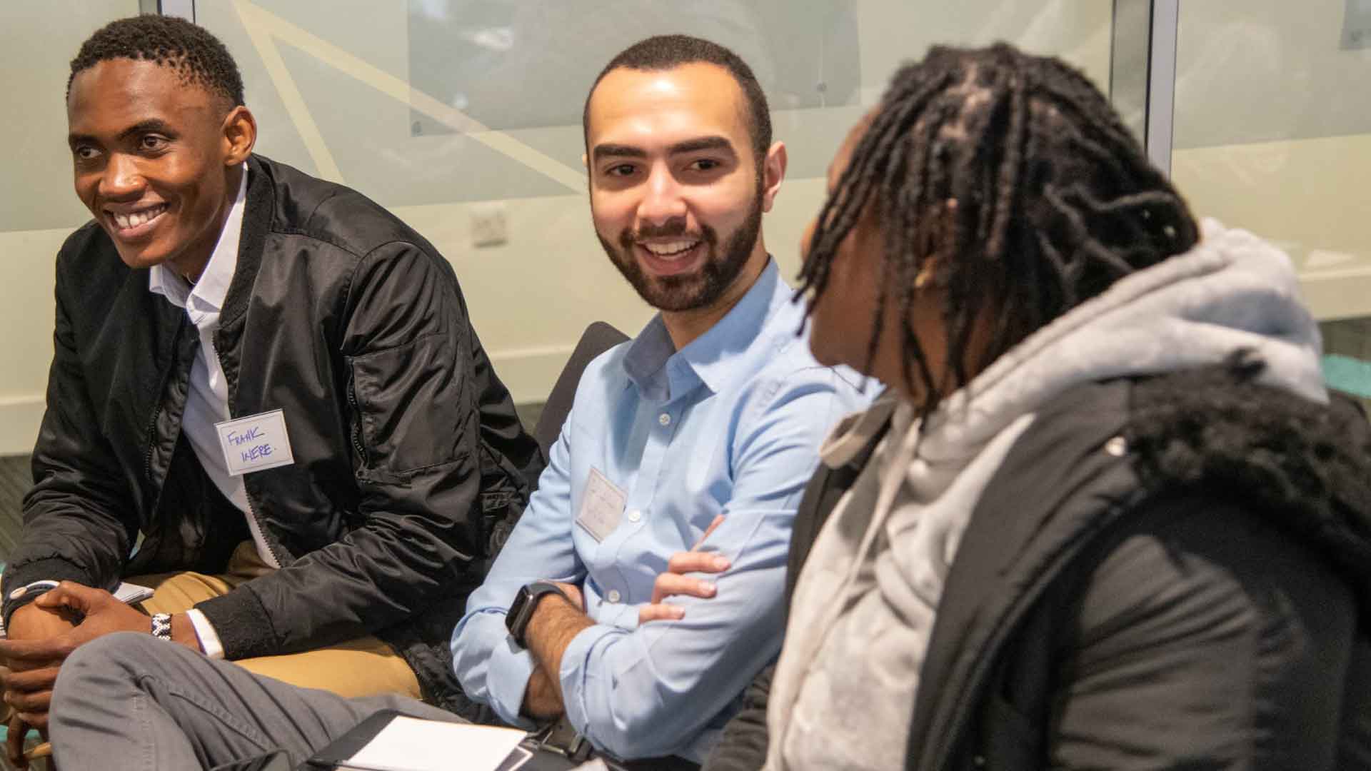 Strathclyde students at a conference, talking to each other.